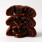 Stack of chocolate cookies with melting chocolate on a white background